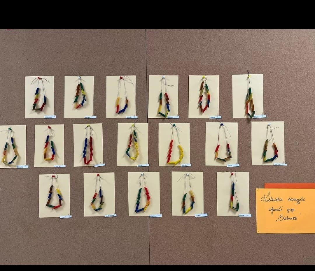 Wystawa z przyklejonych do kartek papieru pomalowanych korali z makaronu